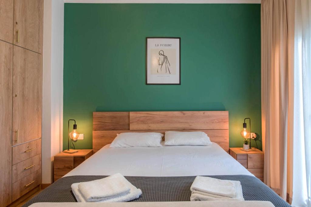 a bedroom with a large bed with a green wall at Iris luxury apartment in Athens
