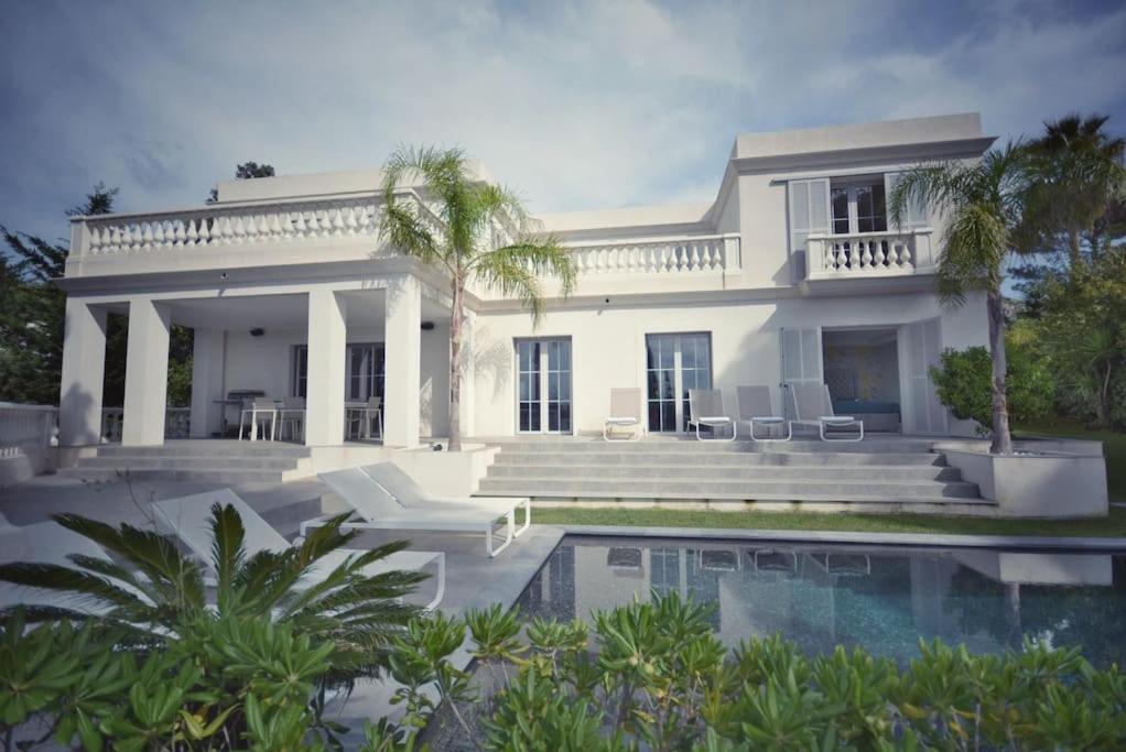 ein weißes Haus mit einem Pool davor in der Unterkunft Cannes, perfect holiday villa with heated pool in Le Cannet