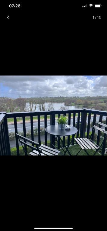 une table et des chaises sur un balcon avec vue sur l'eau dans l'établissement Vue sur Marais et 500 m de la plage, à Villers-sur-Mer