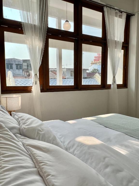 a bedroom with a bed and two windows at Sabay Home in Bangkok