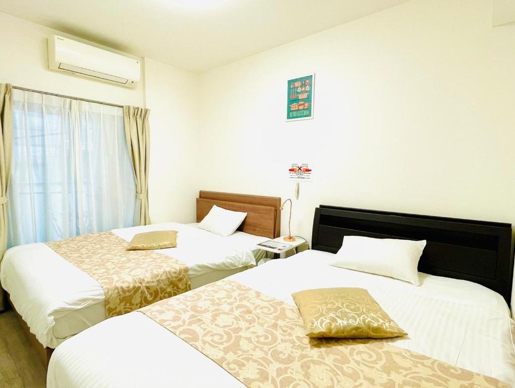 ein Hotelzimmer mit 2 Betten und einem Fenster in der Unterkunft Legatio Hakataekihigashi Hotel in Fukuoka