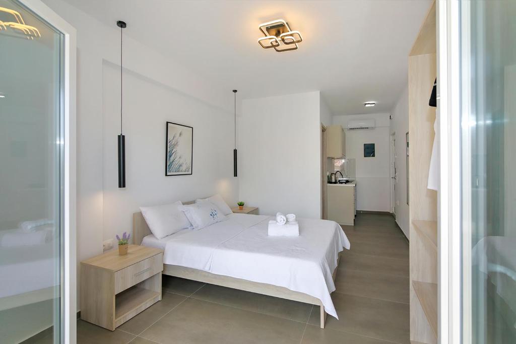 a bedroom with a white bed and a bathroom at AR APARTMENTS in Nikiti