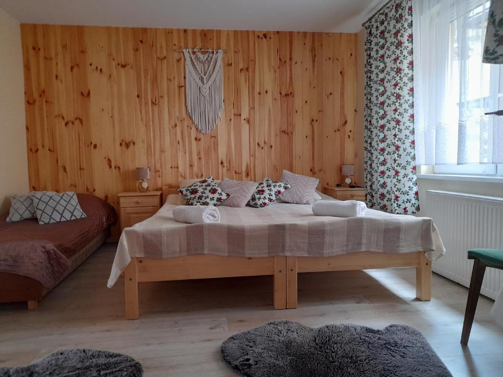a bedroom with a bed in a room with wooden walls at Bodziuchówka in Mizerna