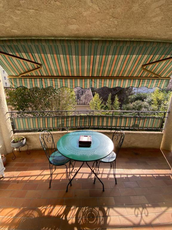 - une table et deux chaises sur la terrasse dans l'établissement T3 62m2 + terrasse ensoleillée Toulon, à Toulon