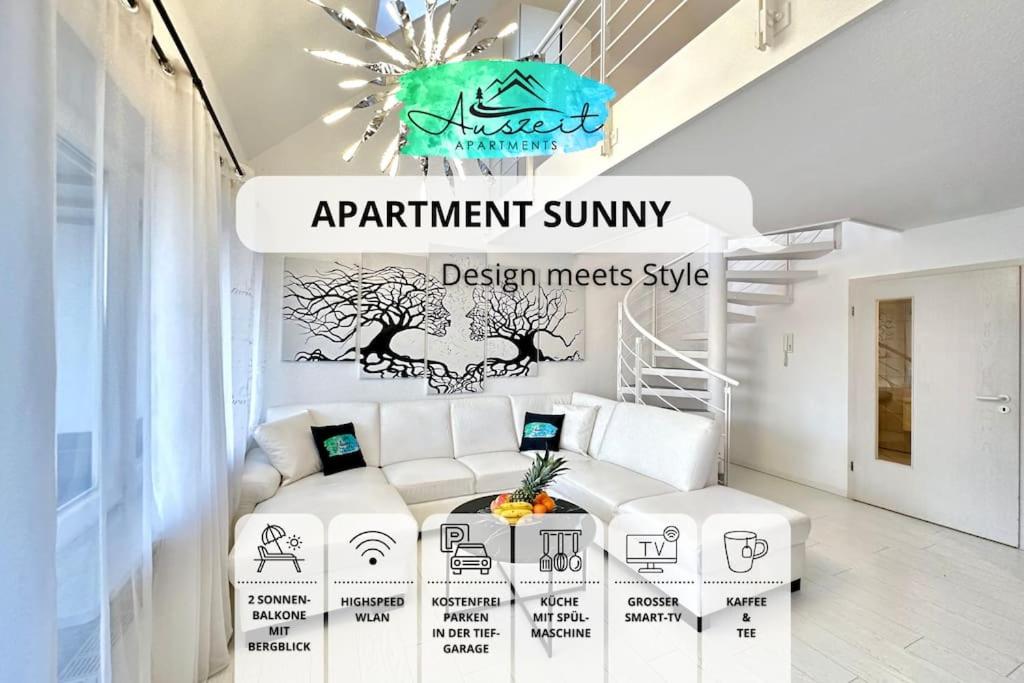 ein Wohnzimmer mit einer weißen Couch und einem Tisch in der Unterkunft Auszeit Apartment SUNNY in Friedrichshafen