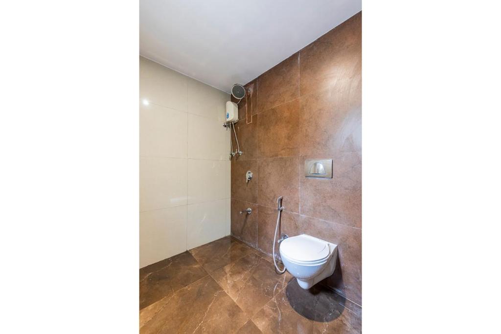 a bathroom with a toilet and a wall at Hotel Green Park in Mumbai