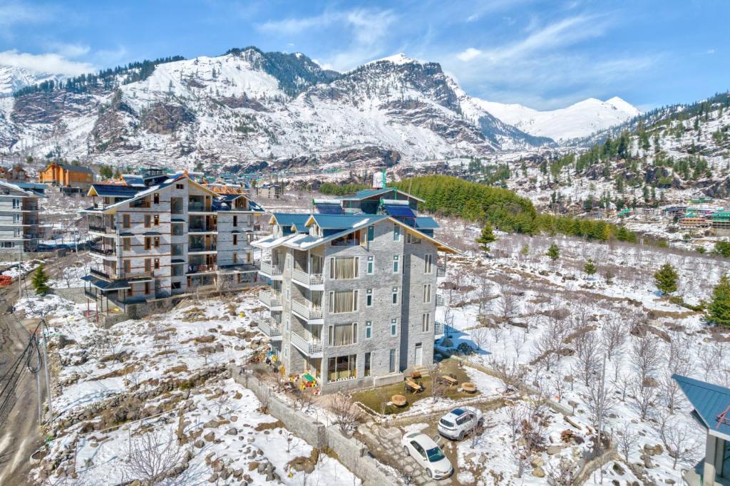 een appartementencomplex in aanbouw met bergen op de achtergrond bij La Aero Resort Home in Snow Mountains in Manāli