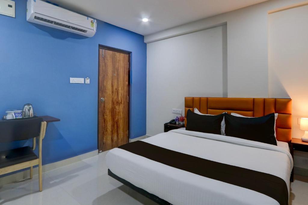 a bedroom with a bed and a blue wall at Townhouse 1338 The Cinco Bliss in Hyderabad