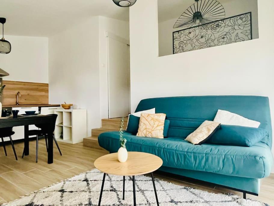 un salon avec un canapé bleu et une table dans l'établissement Studio au cœur des Alberes, à Laroque-des-Albères