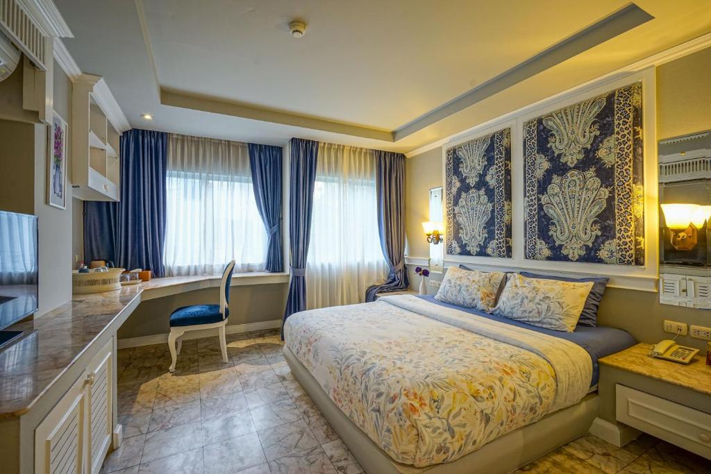 ein Hotelzimmer mit einem Bett und einer Küche in der Unterkunft At Pingnakorn Hotel in Chiang Mai