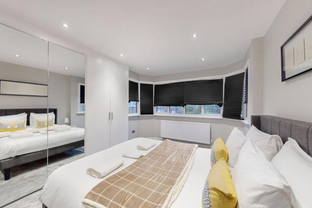 a bedroom with two beds and a glass wall at Brand New 3BDR with Garden&Free Parking in Hendon in Hendon