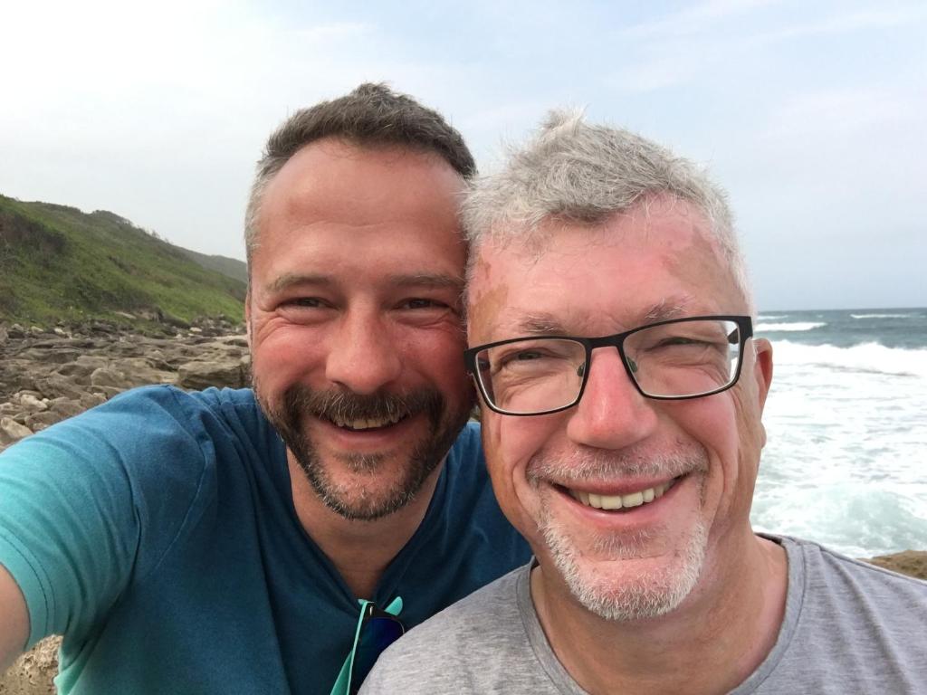 twee mannen poseren voor een foto op het strand bij Apartment in zentraler Lage in Willich in Willich