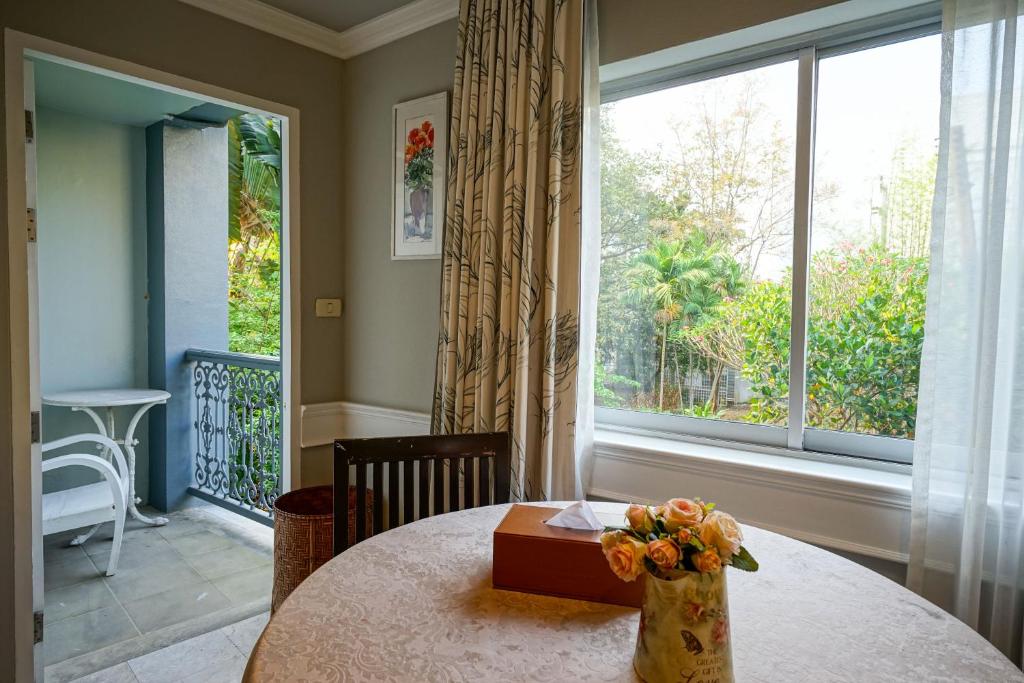 A round dining table beside a large window and a small outdoor balcony.