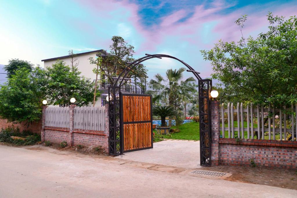a gate in front of a white fence at Phúc Hưng Kazin Homestay Ba vì in Ba Vì