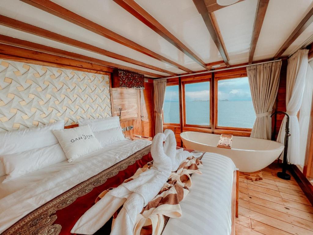 a bedroom with a bed and a tub and a sink at Dav-Venture in Labuan Bajo