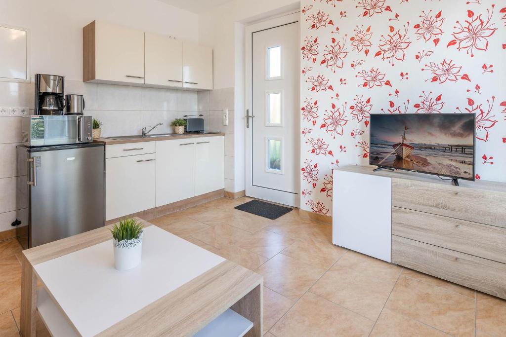 a kitchen with white cabinets and a table in it at Ferienwohnung Sonneneck in Kachlin