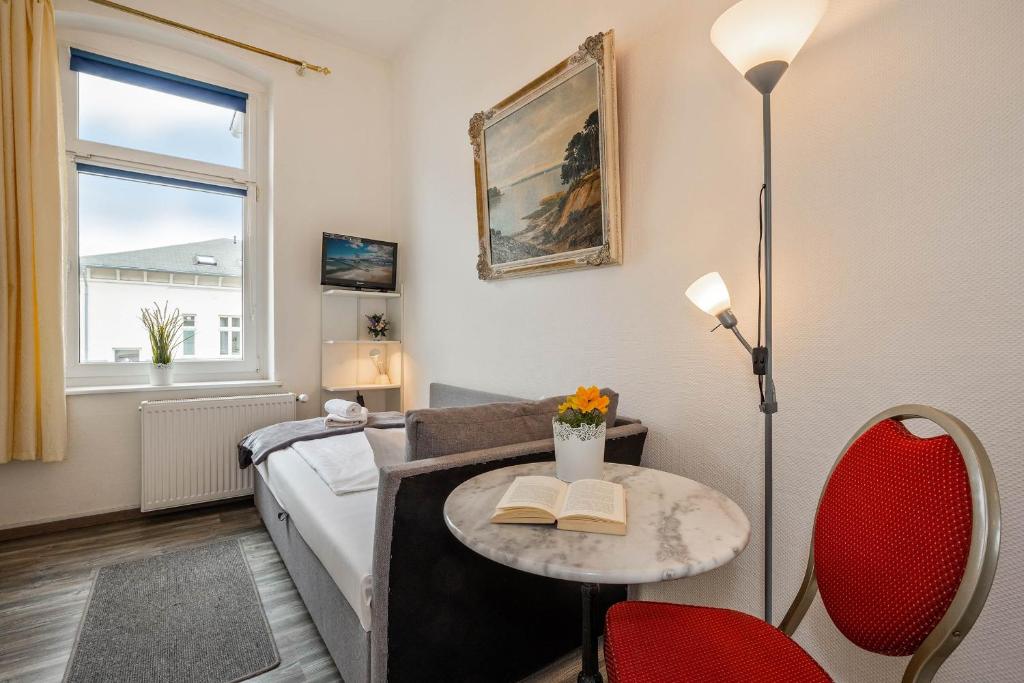 een slaapkamer met een bed en een tafel met een boek bij Villa Seeland Villa Seeland App 3 in Heringsdorf