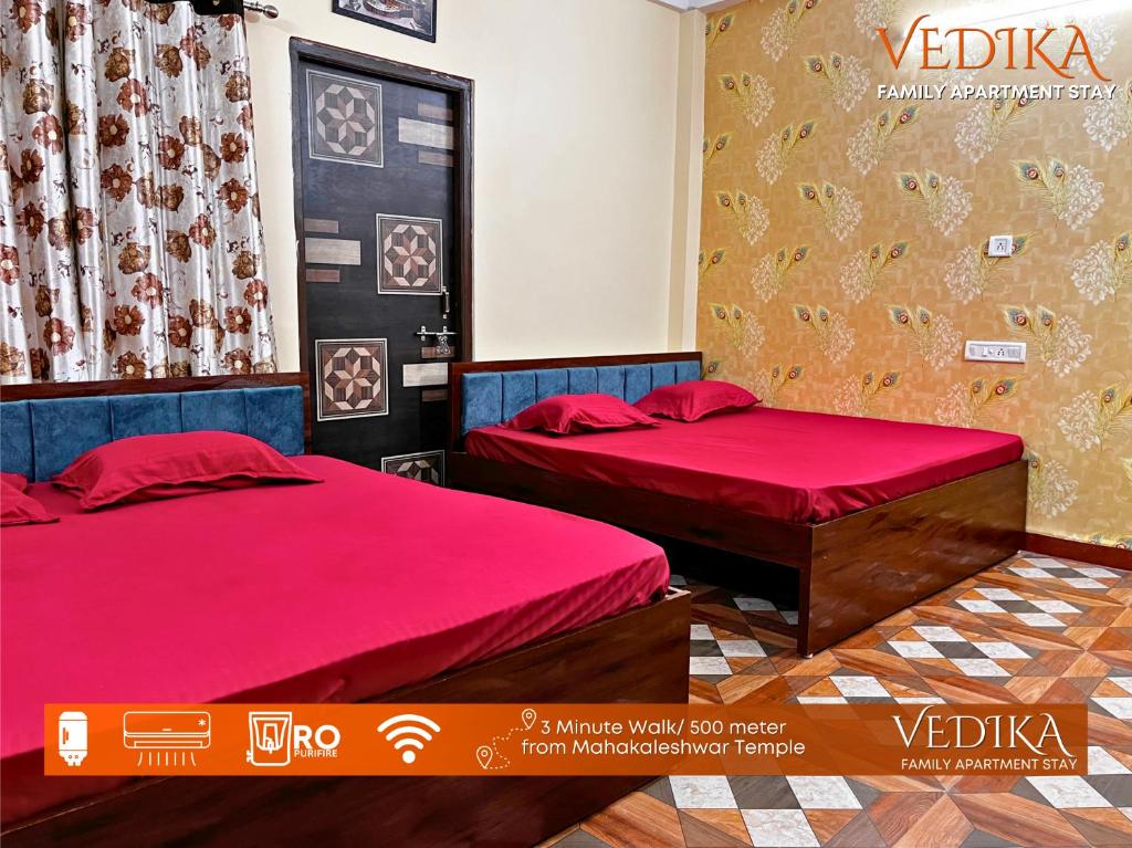 two beds in a room with red sheets at Vedika Yatri Grah - Entire Apartment in Ujjain