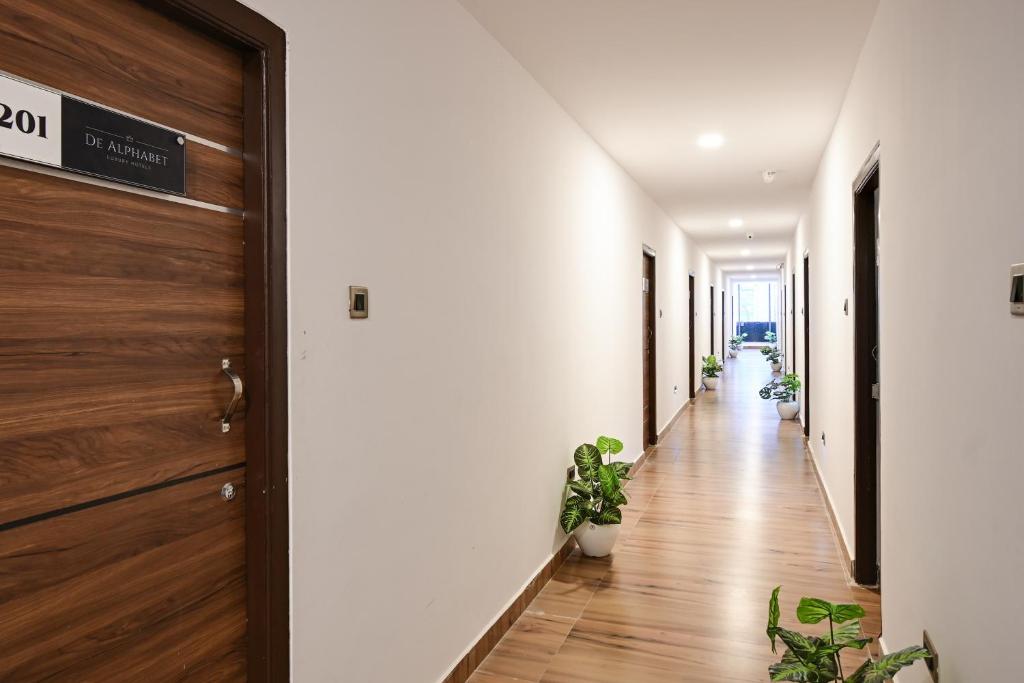 a hallway with potted plants and a door at Townhouse De Alphabet Karmanghat in Hyderabad