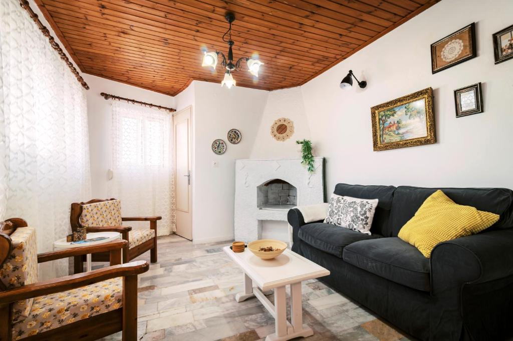 sala de estar con sofá y chimenea en Olympia's Cozy Guesthouse, en Psinthos
