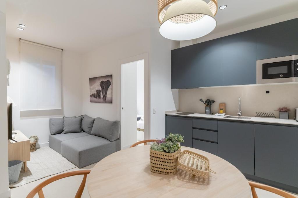 Il comprend une cuisine et un salon avec une table et un canapé. dans l'établissement Modern and cozy-1Bedroom 1Bathroom-Azca, à Madrid