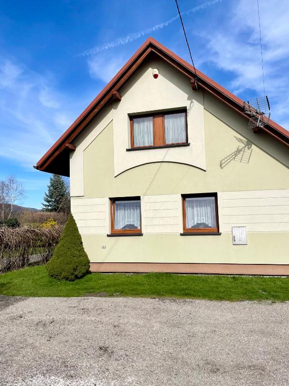 a house with three windows on the side of it at Domek u Kacpra in Jeleśnia