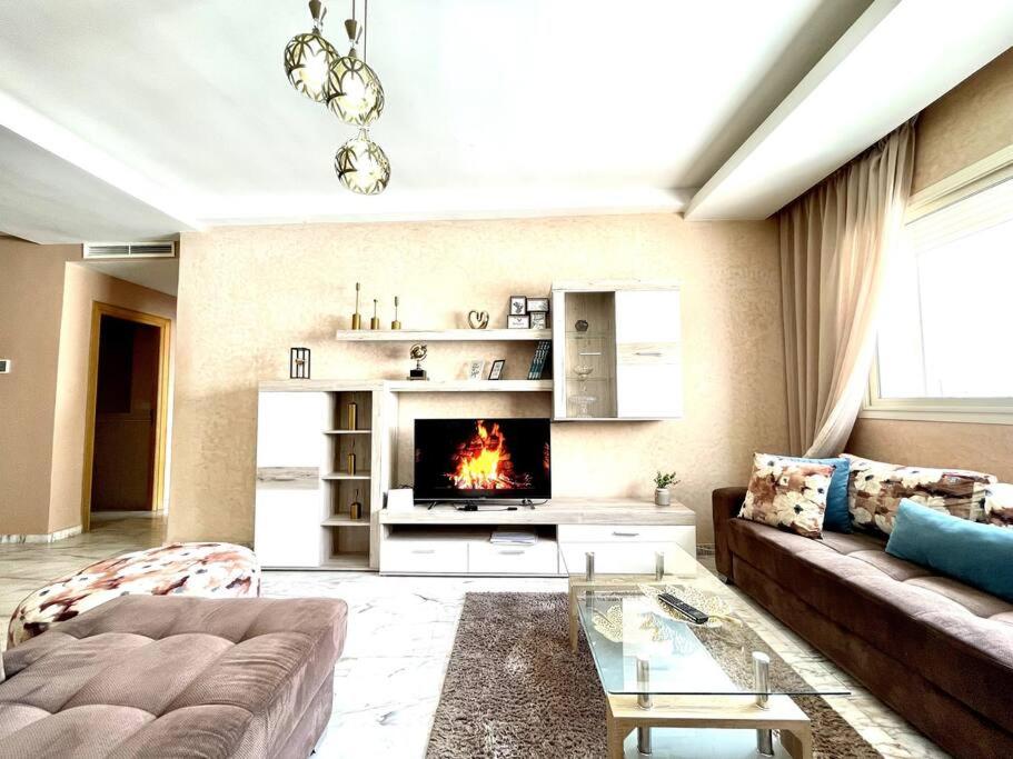 a living room with a couch and a fireplace at Late&Early Flight cozy Apartment in Nouaseur