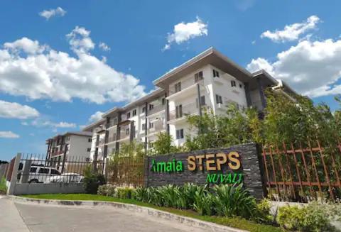 a building with a sign in front of a fence at Urban Zen in Calamba