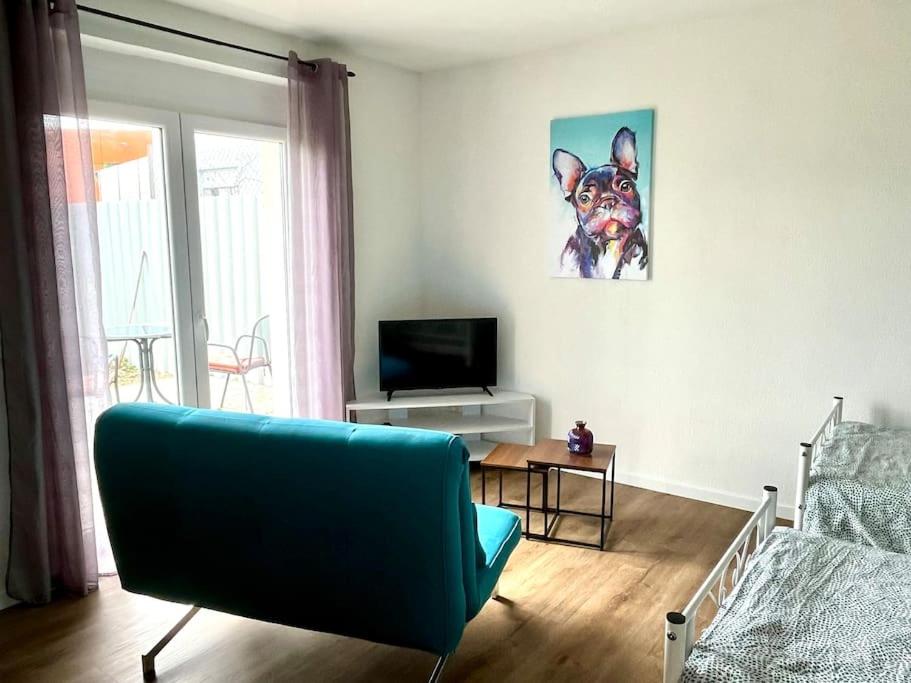 un salon avec un canapé bleu et une télévision dans l'établissement Ferienwohnung Herbolzheim, à Herbolzheim