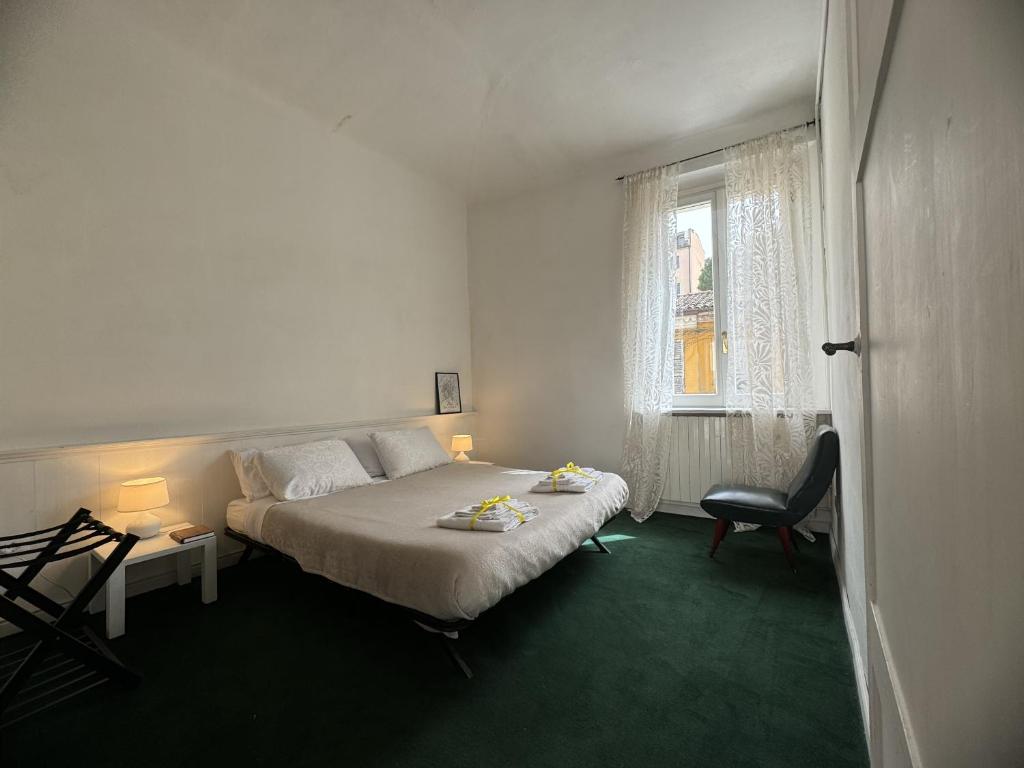 a bedroom with a bed and a chair and a window at Maison Leone Apartment in Ravenna