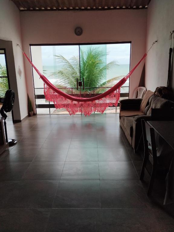 a living room with a hammock in the middle of a room at Xareu-Balanço das Ondas! in Cabo de Santo Agostinho