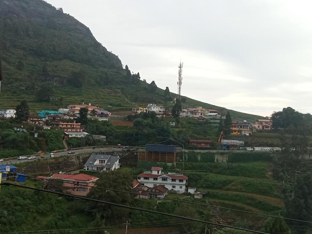 a village on a hill with a mountain at Lovedale homestay in Ooty