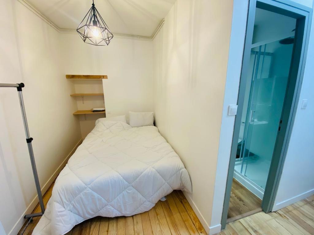 ein kleines Schlafzimmer mit einem Bett und einer Glastür in der Unterkunft Studio in Cauterets