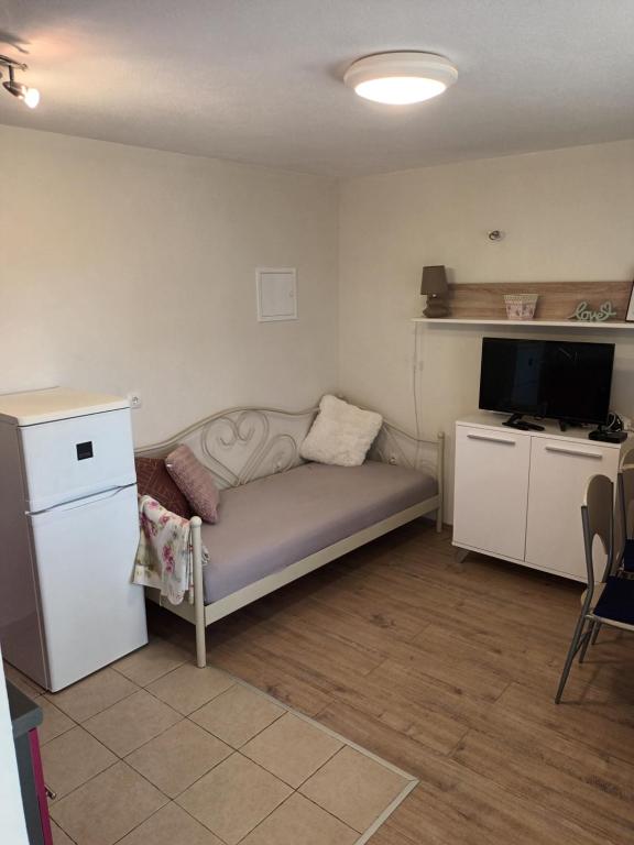 Pokój z łóżkiem, telewizorem i lodówką w obiekcie Apartment Maro w Szybeniku