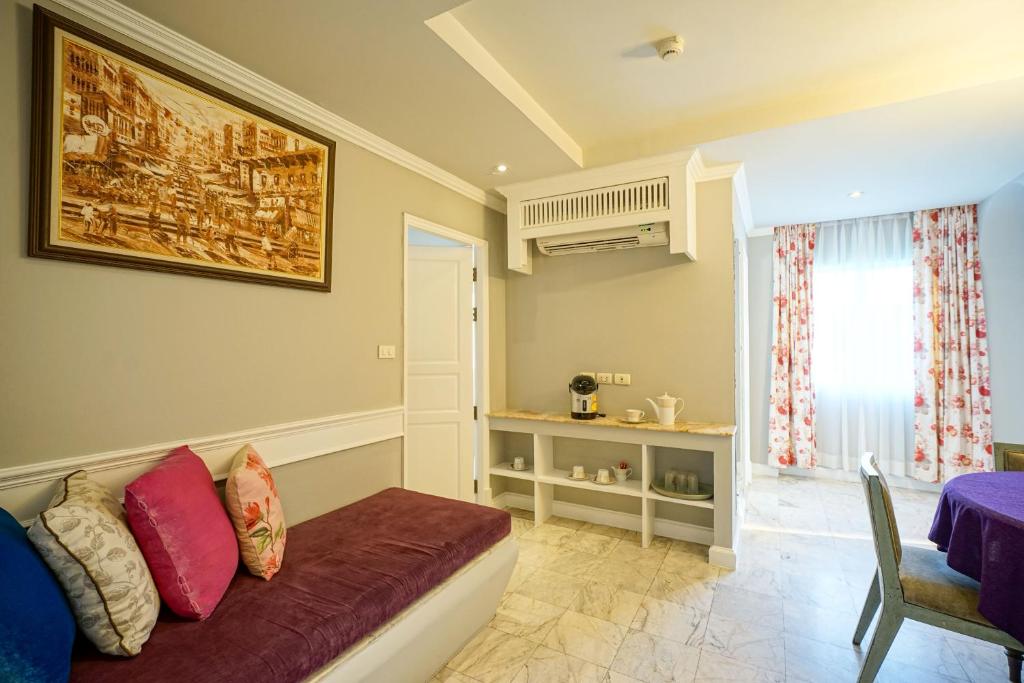 A sitting area adjoining the bedroom, with a sofa, beverage station and windowed dining space.