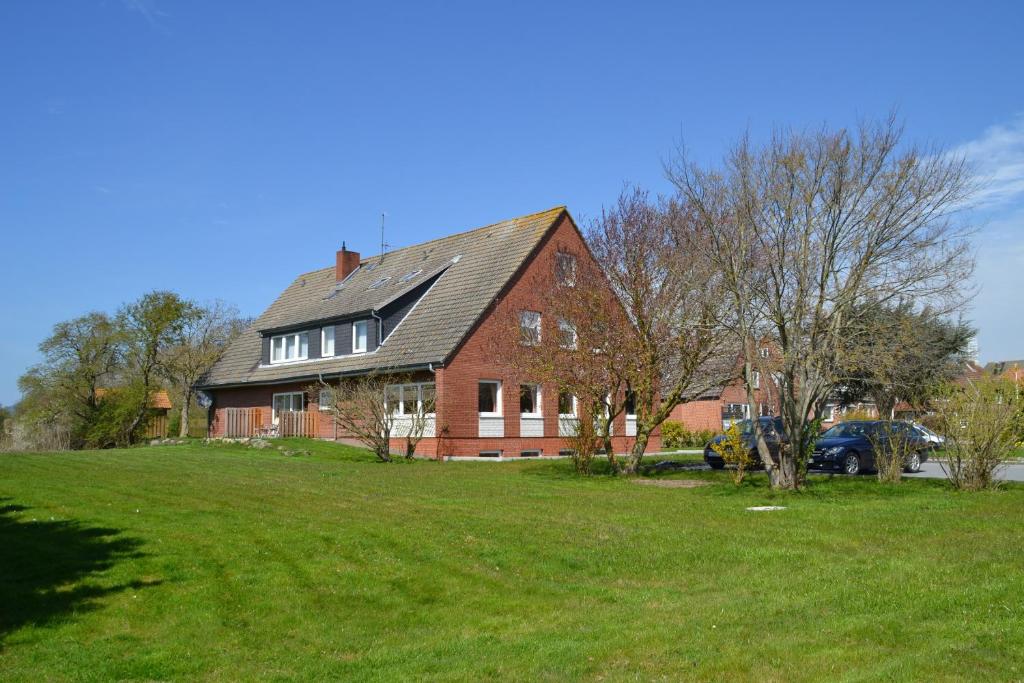 a large red brick house with a green yard at Haus Widder Nr2 in Kopendorf