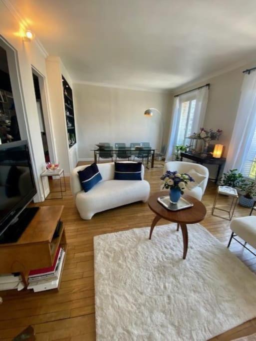 Una sala de estar con un sofá blanco y una mesa. en Luxurious appartement Montreuil, en Montreuil