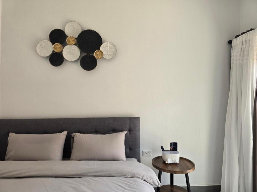 a bedroom with a bed and a clock on the wall at Airanda Phuket Homestay in Ban Suan