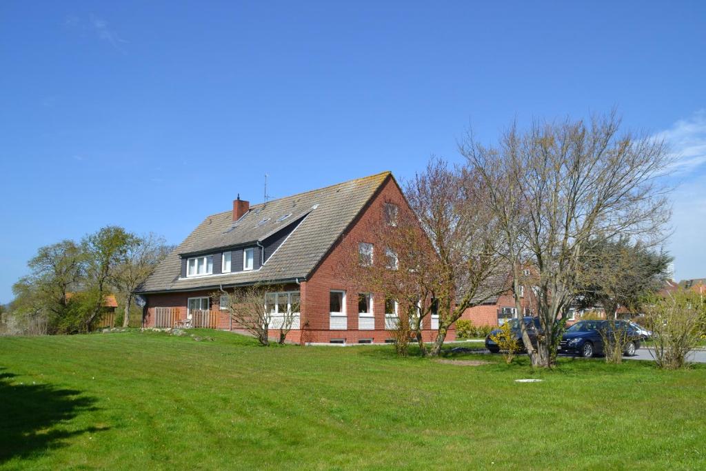 a large red brick house on a green field at Haus Widder Nr3 in Kopendorf