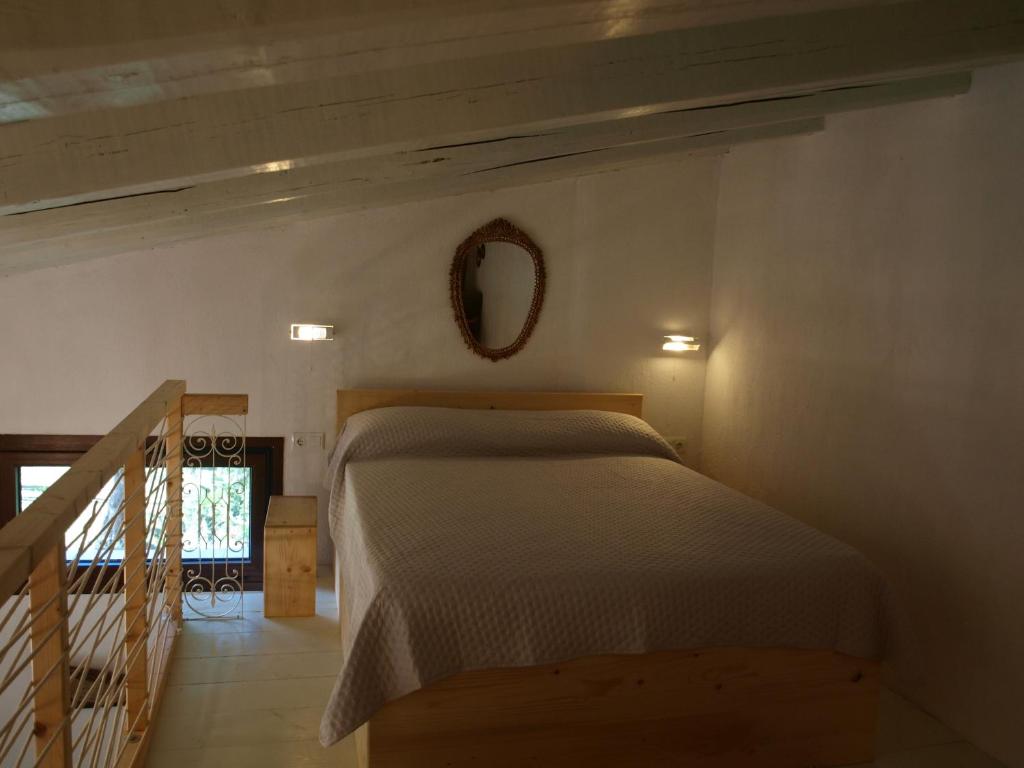 Schlafzimmer mit einem Bett und einem Wandspiegel in der Unterkunft Country House Spitaki Λόχος in Velika