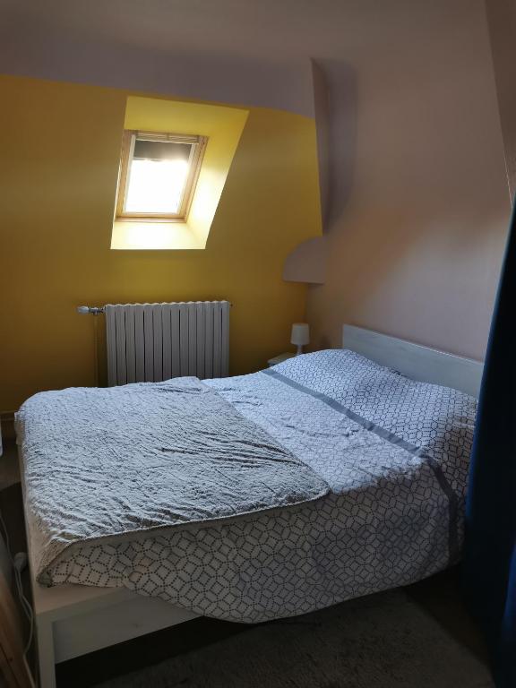 een slaapkamer met een bed en een raam bij CHAMBRE LIT DOUBLE in Montbizot