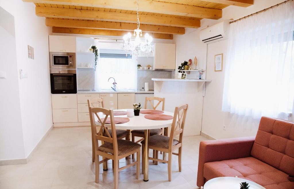 Una cocina y un comedor con mesa y sillas. en Vízitündér Pihenőpark Apartmanok, en Újhartyán