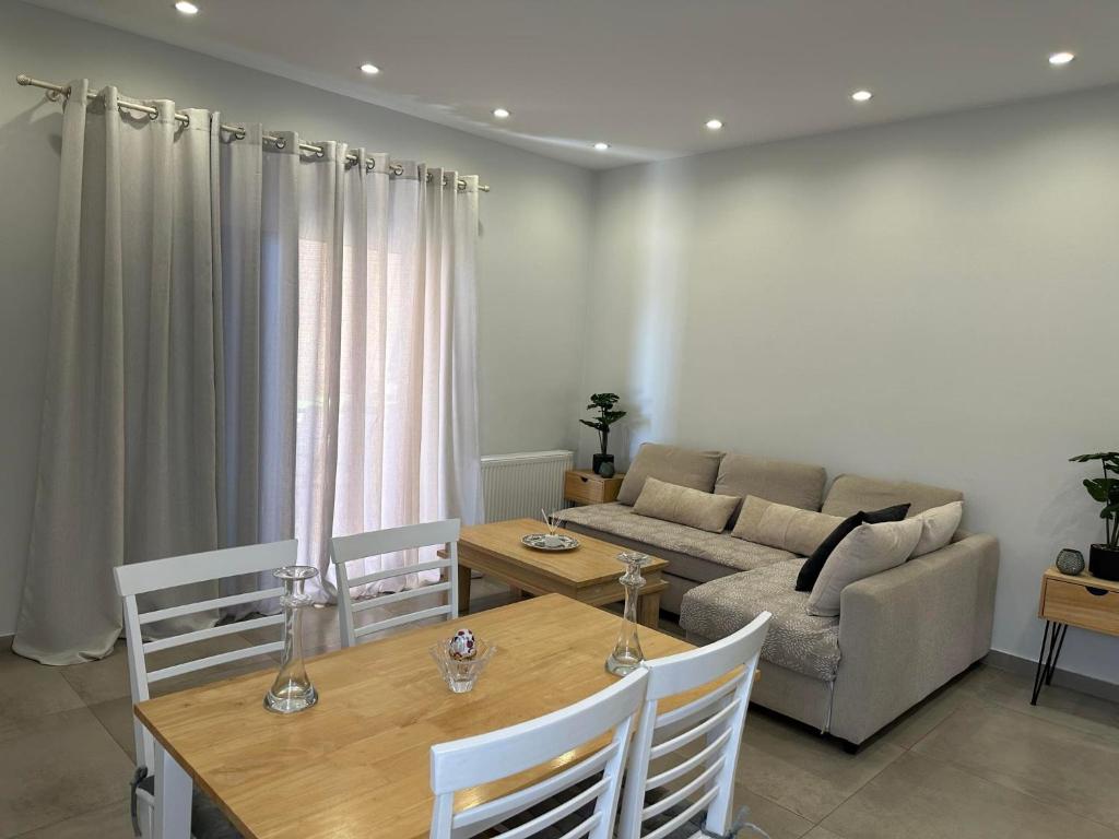 Mimozas Apartment Porto Heli في بورتوخيلي: غرفة معيشة مع أريكة وطاولة