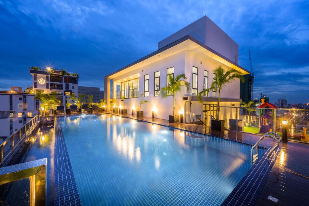 a swimming pool in front of a building at night at Mansion 51 Hotel & Apartment in Phnom Penh