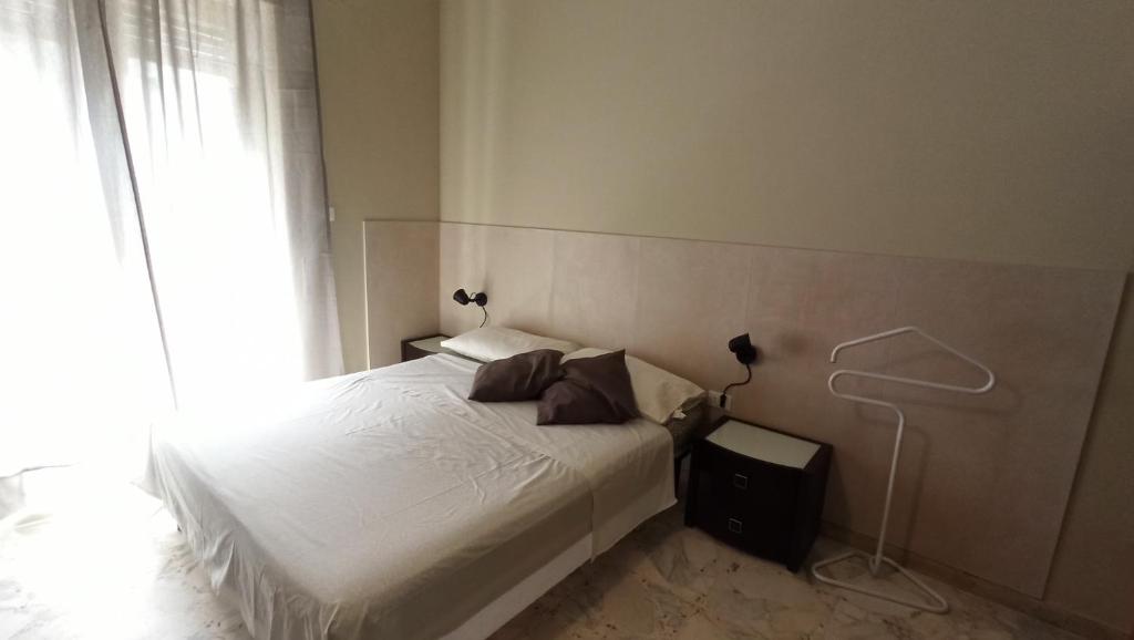 a bedroom with a white bed and a window at Don Aurelio in città - 2 in Acireale