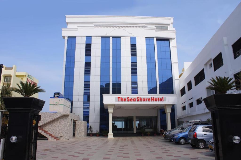 a building with a sign in front of a parking lot at THE SEASHORE HOTEL in Kanyakumari