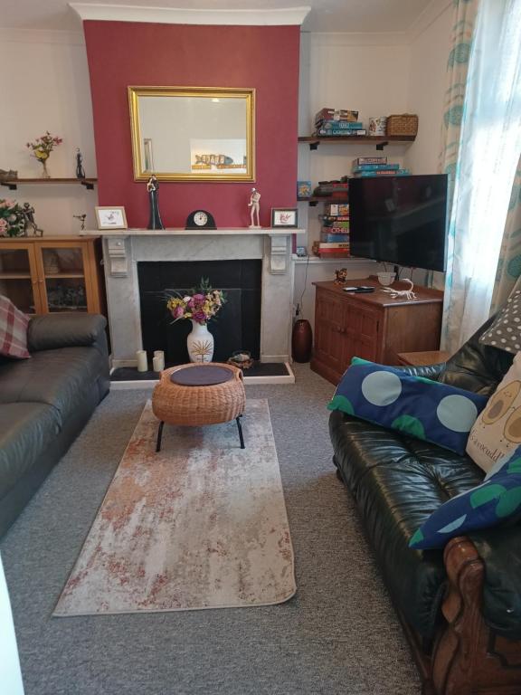 uma sala de estar com um sofá e uma mesa de centro em Cheerful 3-bedroom townhouse with free parking on site em Taunton