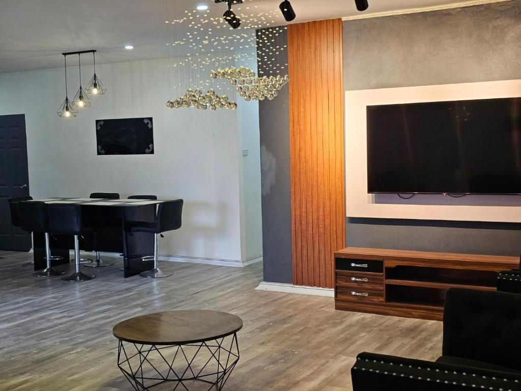 a living room with a table and a flat screen tv at Moutain View Villa in Pacific Harbour