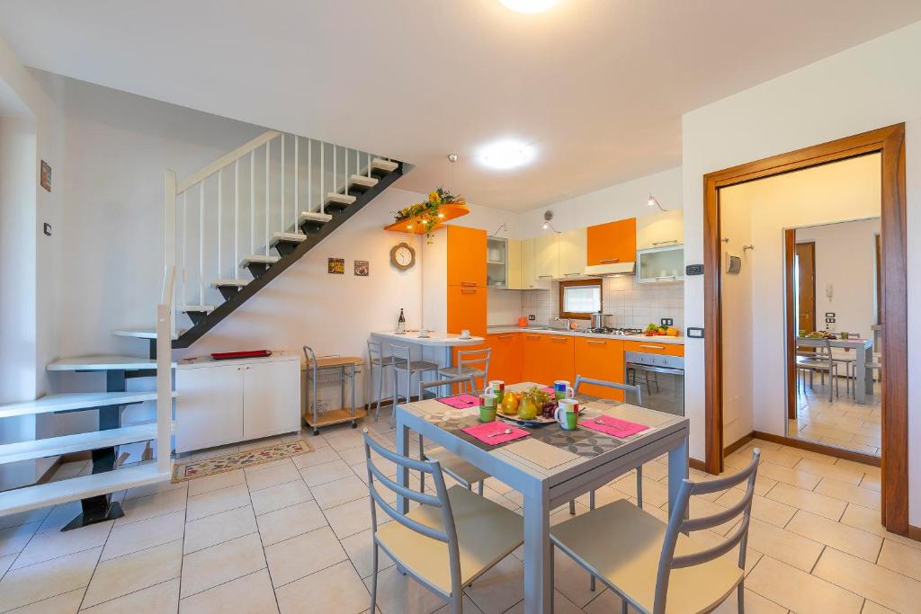 kuchnia i jadalnia ze stołem i schodami w obiekcie VistaLago Green Residence 100m From Lake - Happy Rentals w mieście Desenzano del Garda