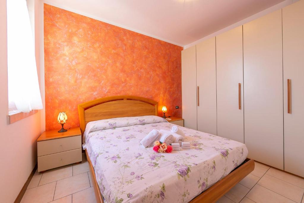 sypialnia z łóżkiem z kwiatami na nim w obiekcie VistaLago Green Residence 100m From Lake - Happy Rentals w mieście Desenzano del Garda